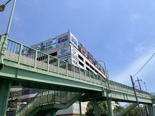 Exterior view of BIG FUN Heiwajima entertainment complex, seen from the pedestrian overpass near the racecourse.